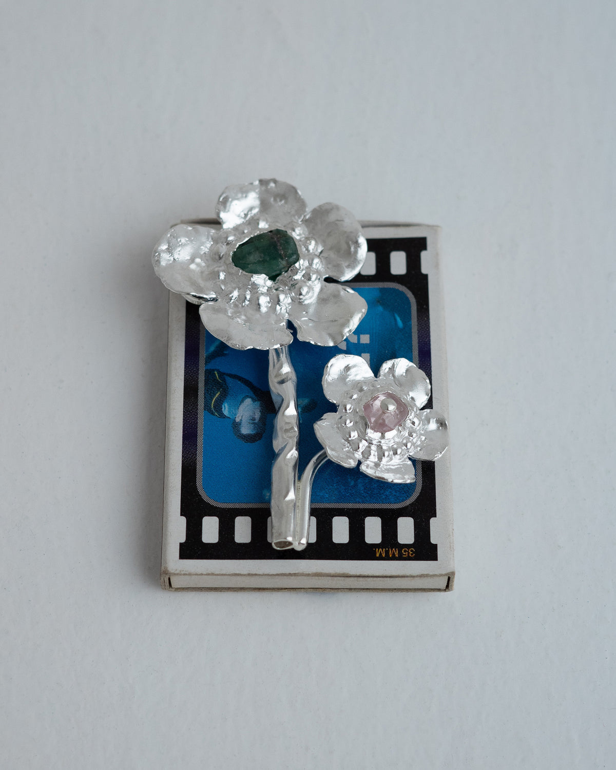 <p>two headed flower brooch with a raw green emerald and a morganite set in 925 sterling silver.</p>
